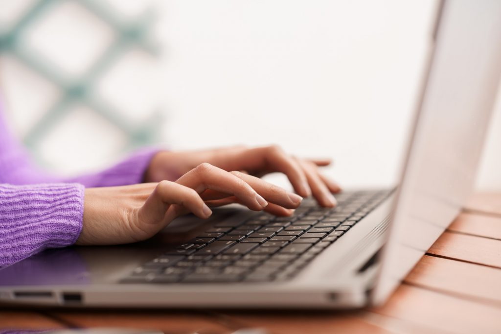 mãos de mulher digitando em computador. simulador minha casa minha vida